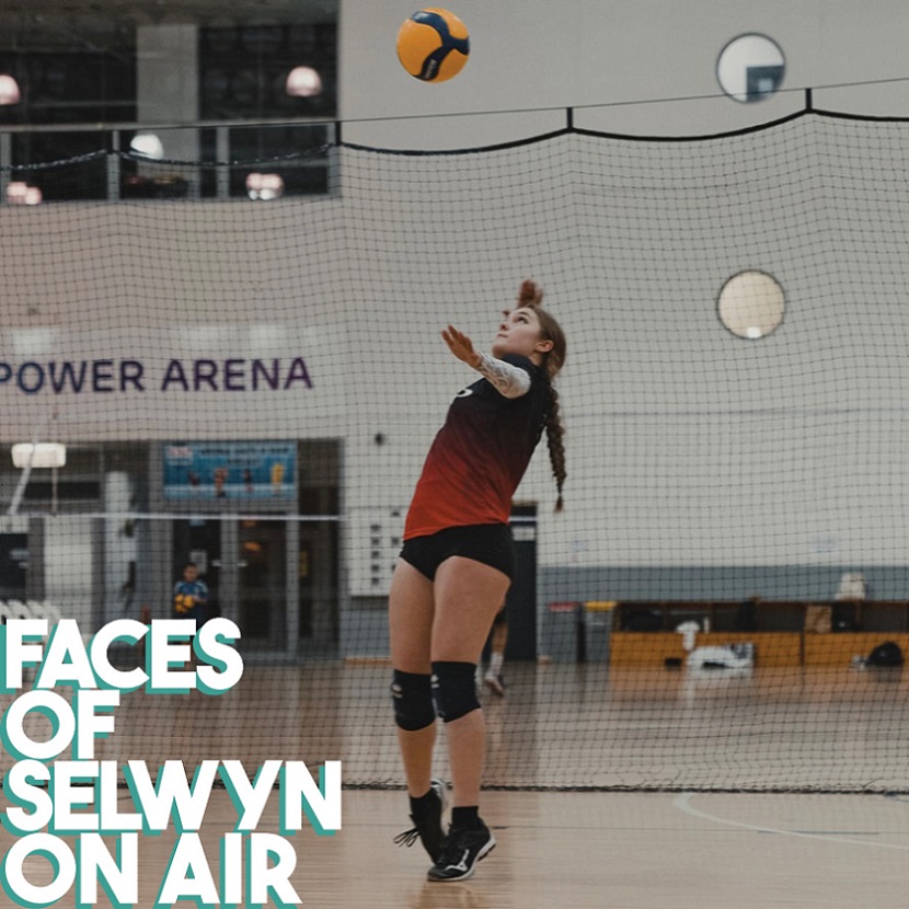 A woman in sports kit serving a volleyball on a court