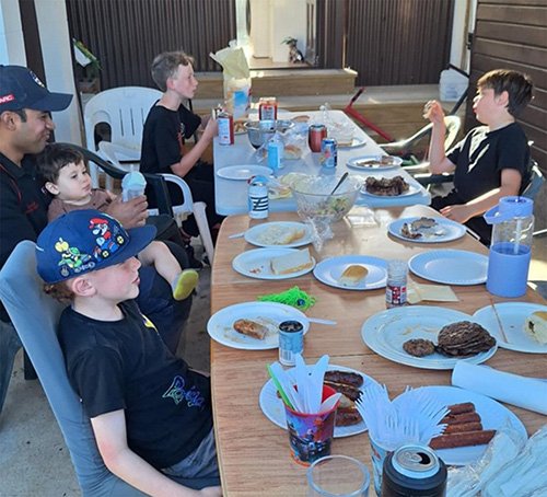 Several children sitting down eating food