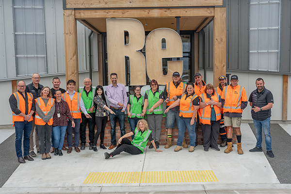 several people pose for photo outside of ReUse shop at the opening