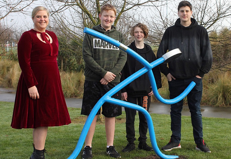Selwyn Libraries' Assistant Librarian Jade Bell and students Bradley Ward, Matt Bool and Noah Yates stand behind a blue dancing sculpture in Brookside Park