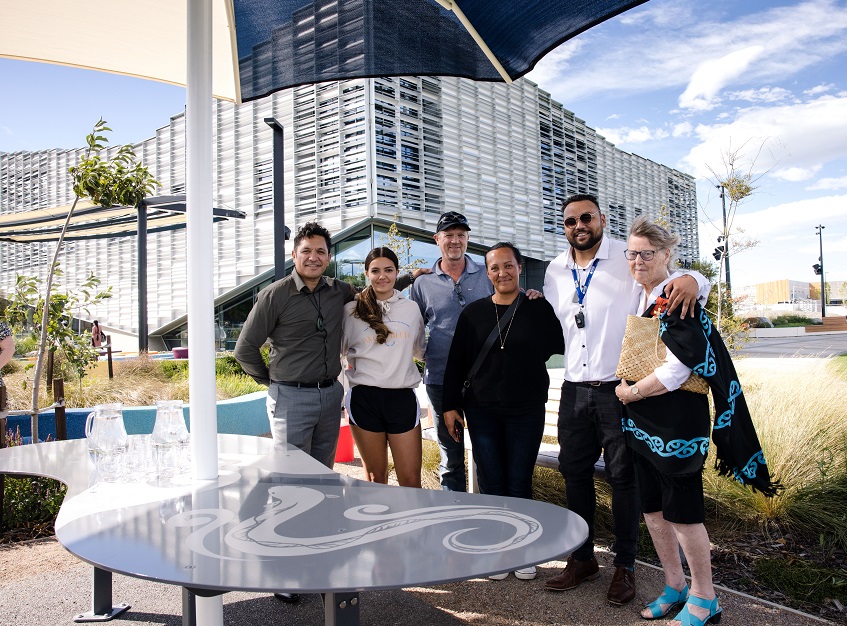 Councillor Shane Epiha, artist Izzy Tinirau-Holt and family, Te Taumutu representative Harrison Hunt and Te Taumutu Kaumatua Denise Sheat stand arm in arm behind the Kai table