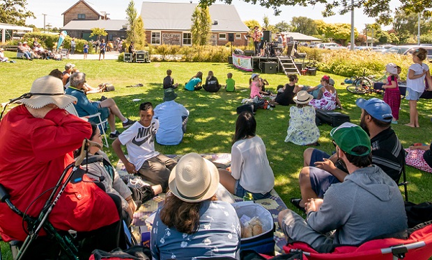 A crowd watches a band perform on the Lincoln Green for Summer in Selwyn