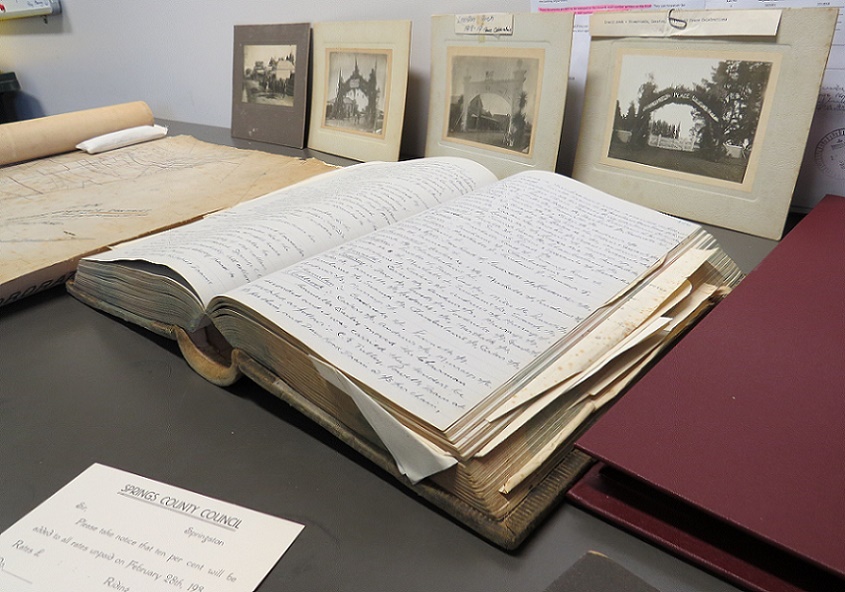 Historic books and photographs laid out on a table
