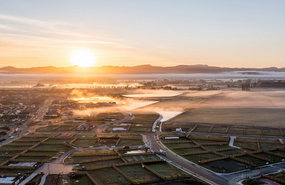 Aerial shot looking into a sunrise over a misty set of fields