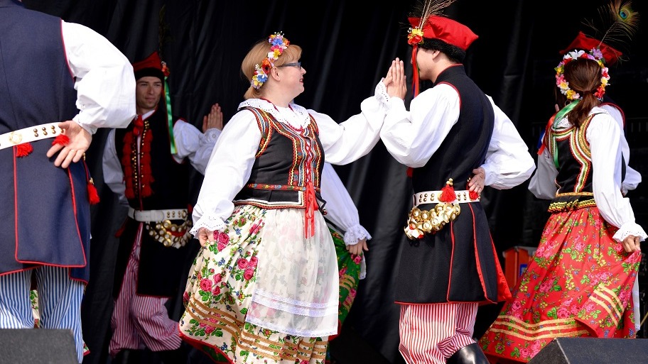 Man and woman in traditional Macedonian dress doing a traditional dance