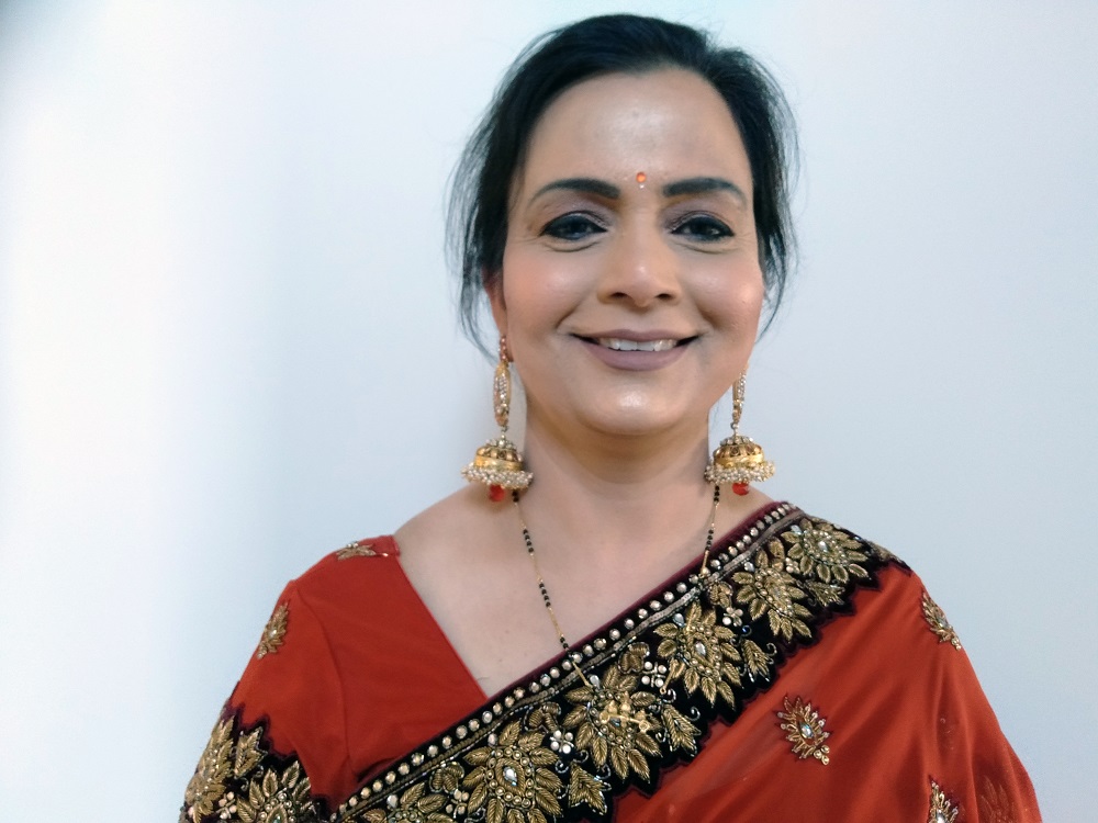 Close up of smiling woman in a red sari and jewellery
