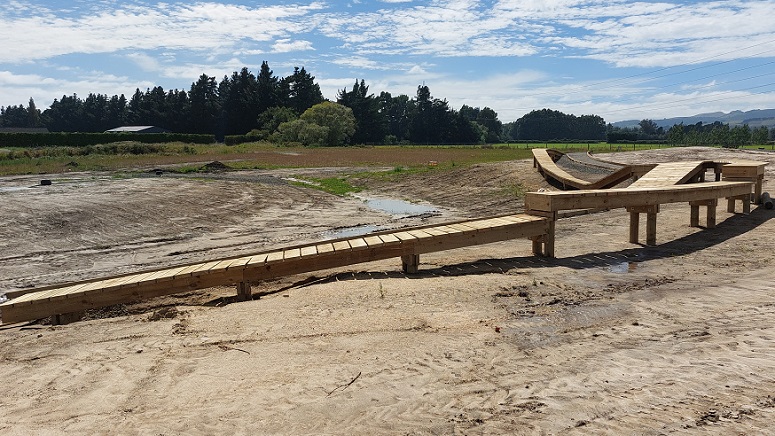 A wooden cycle path on cleared ground at Springs Park