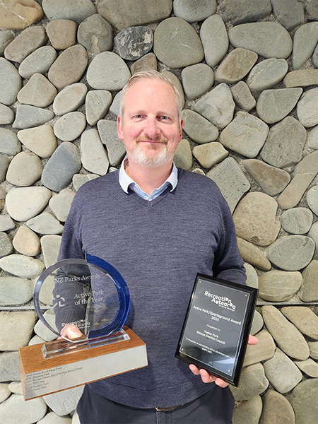 Council employee holding two award trophies