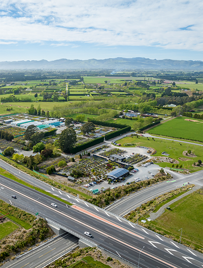 Road with cars ad township and rural landscapes in background