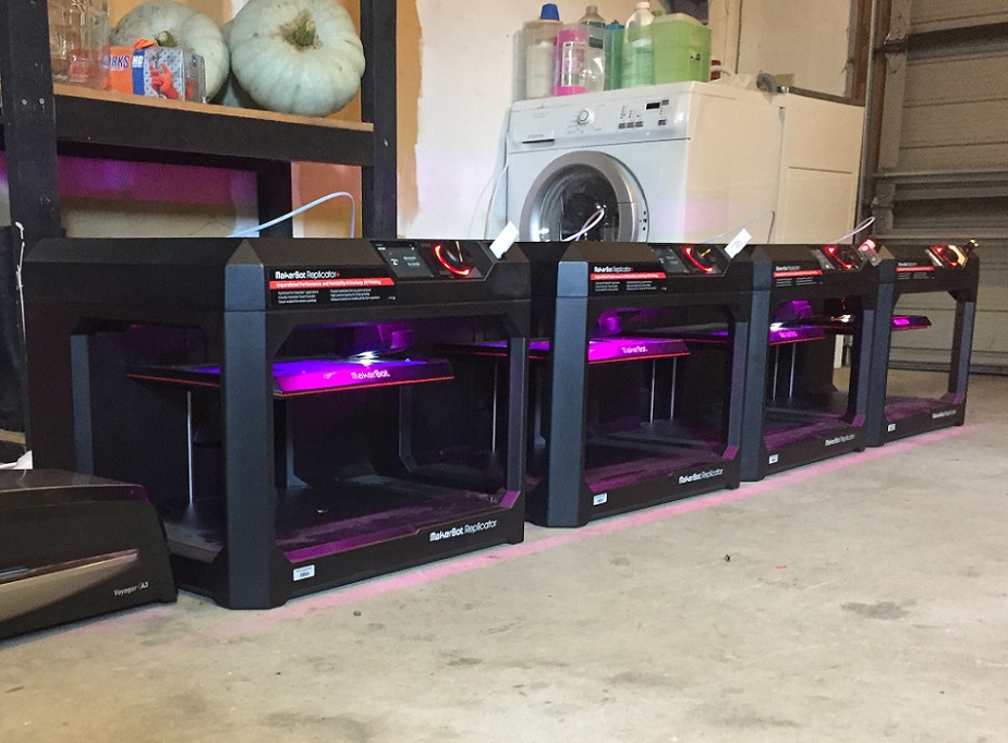 A row of 3D printers in a garage