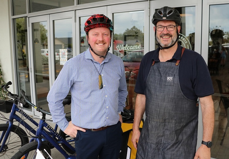 Mayor Sam Broughton and Rolleston Robert Harris Cafe owner Phil Deans with their cycle helmets on and bikes in the background