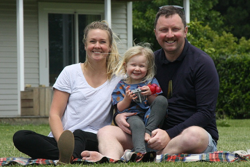 Mayor Sam Broughton and his family sit together on a lawn outside a house