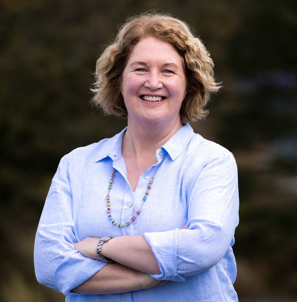 Mrs Mason smiling with arms crossed looking at camera