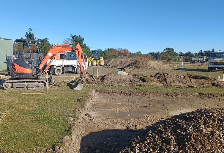 A construction site with diggers and a truck 