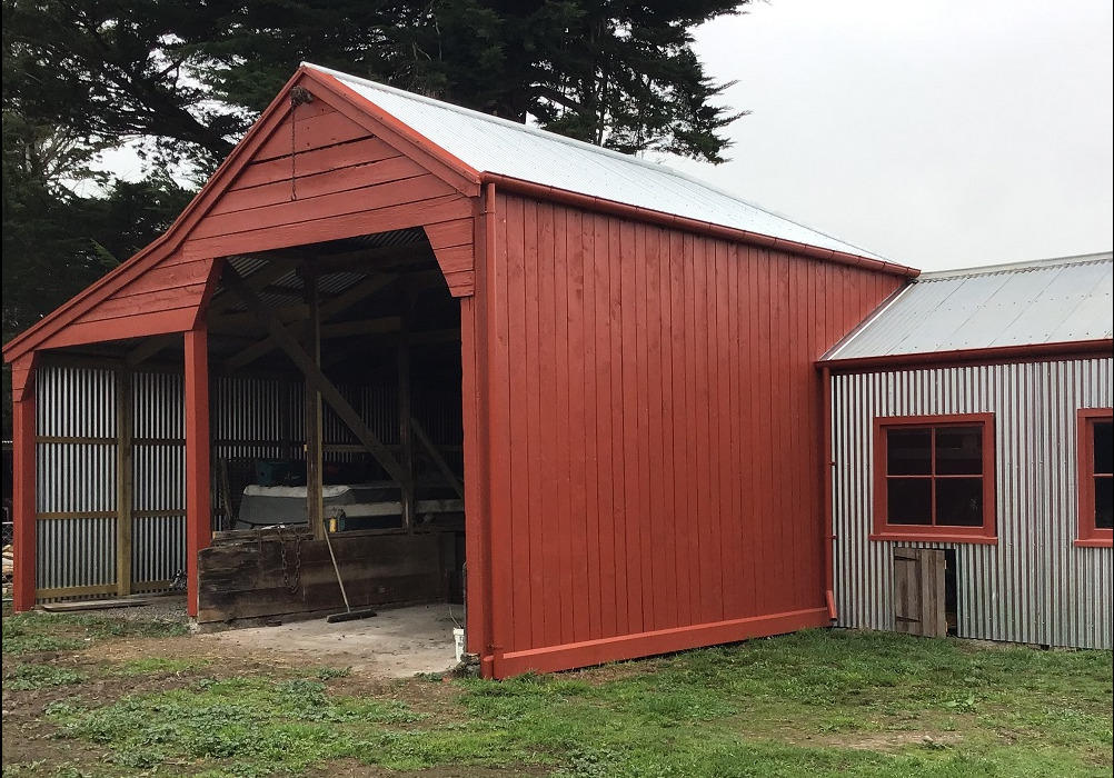 The restored shed painted in red
