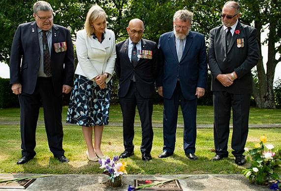 Dignitaries RNZRSA president BJ Clark, Selwyn MP Amy Adams, Minister for Veterans Ron Mark, Selwyn Deputy Mayor Malcolm Lyall and RSA Canterbury District President Stan Hansen stand in a line with heads bowed looking at one of the newly unveiled plaques