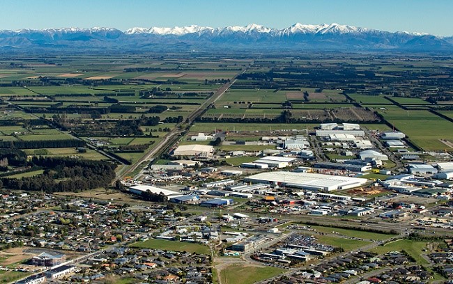 An aerial view of Rolleston looking over houses, I-zone and out to the Southern Alps