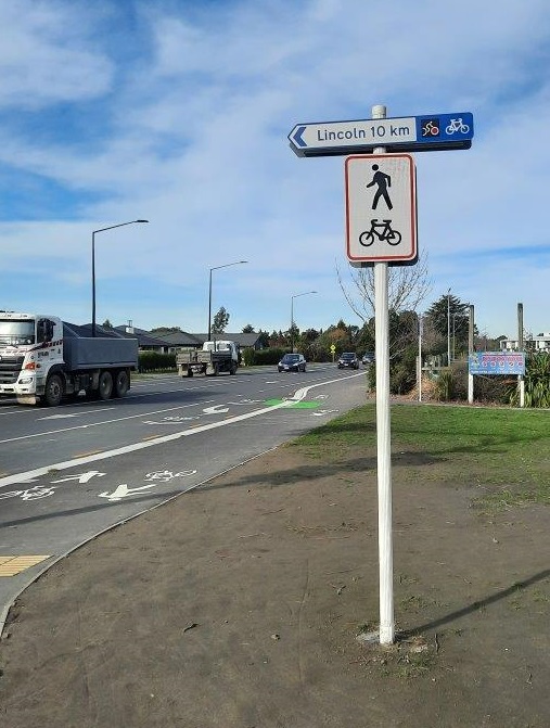 Picture of a shared patch sign and the path behind