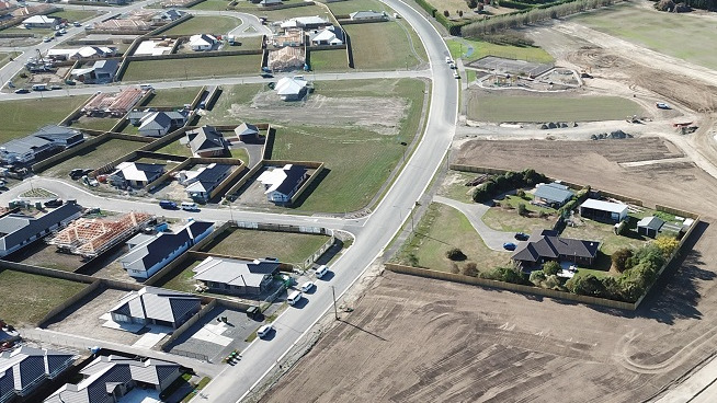 aerial view of a partially built subdivision with a mix of completed houses, partially built houses and bare sections