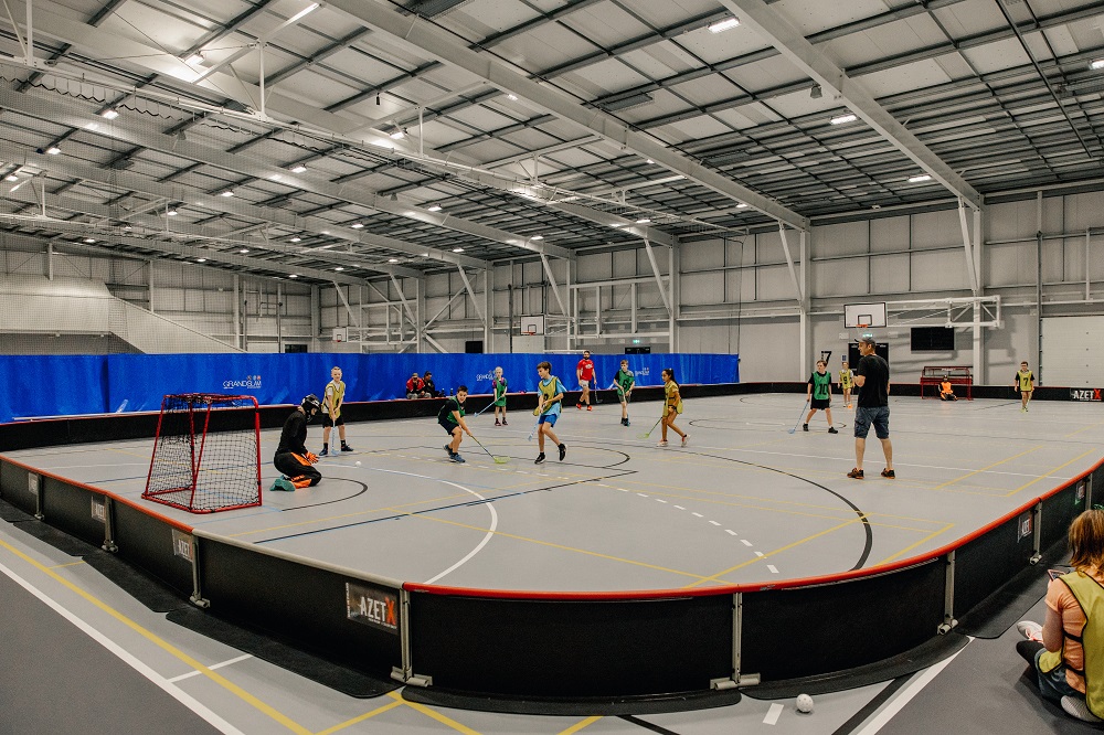 A group of children playing hockey in the Selwyn Sports Centre