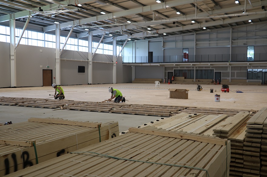 Two men nail down wooden floor boards at the Selwyn Sports Centre