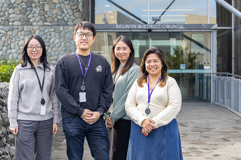 four students stand in front of council building