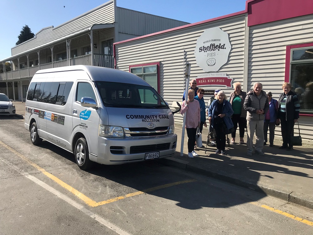 A group of older residents outside the Sheffield Pie Shop next to a silver Rolleston Community Care van