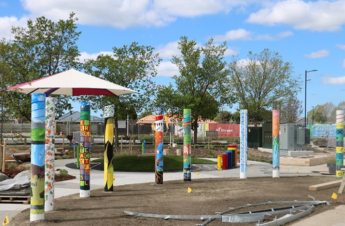 colourful poles in front of a shade sail and paths