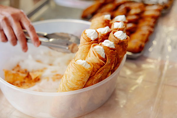 Brown pastry rolls with cream stacked standing up