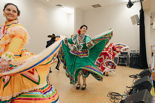 Two women very colourful in dress dancing 