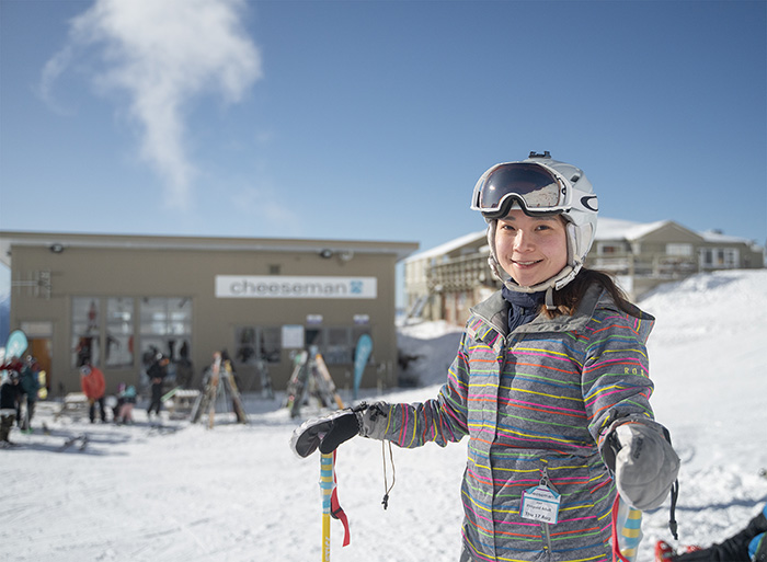 Girl skiier in front of cheeseman ski field lodge
