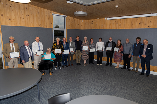 Several community members standing in a row with certificates in hand 