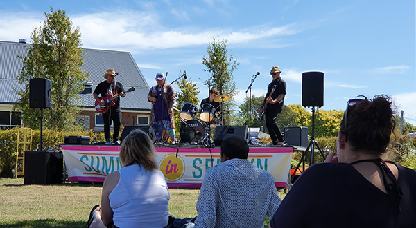 A band on stage playing instrucments in front of a crowd