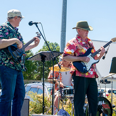 A band of musicians playing guitar, bass and drums