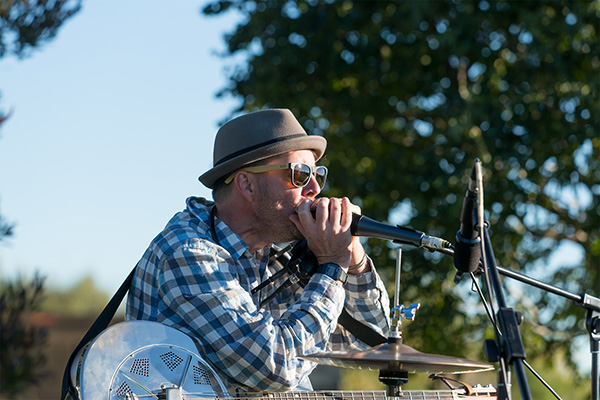 Male singer with sunglasses sings into a microphone