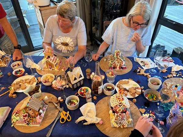 Two women making gingerbread houses
