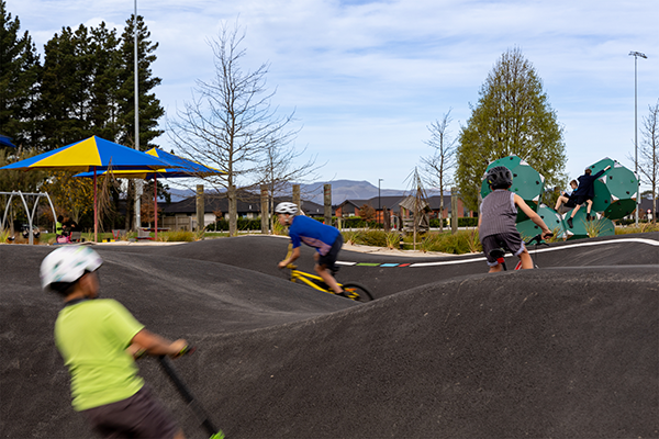 Three kids biking at bike park
