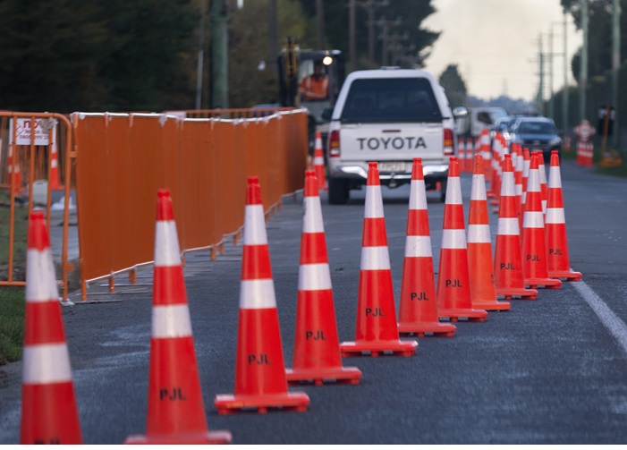 White ute travelling through road works surrounded by road cones