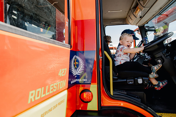 Young child sits at drivers seat of Fire Engine 