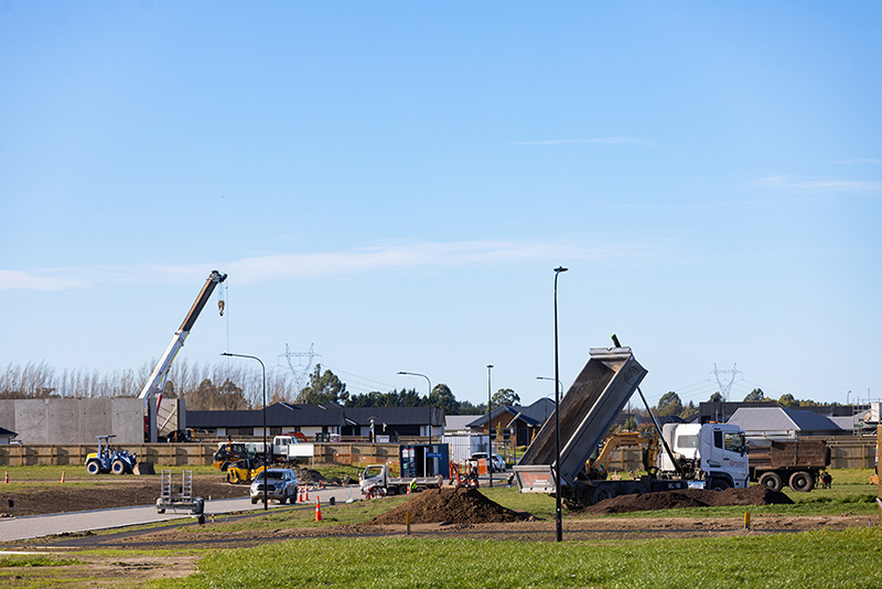 Dump truck in new subdivision surrounded by buildings