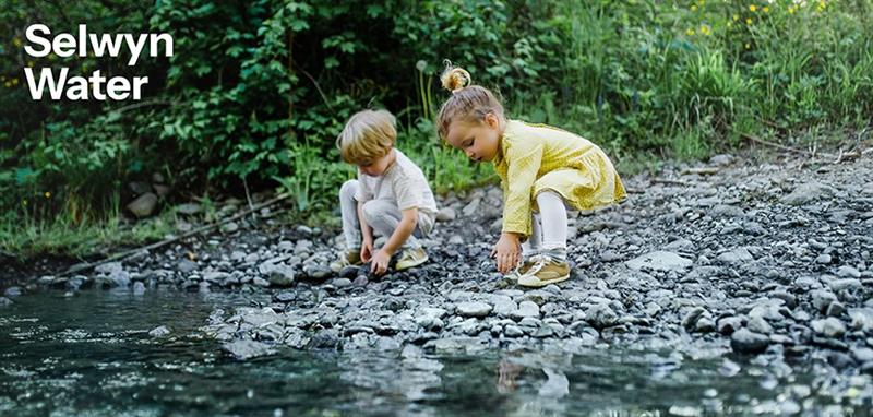 Two children at water edge of river