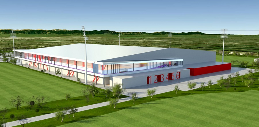 An artists impression of the new indoor courts showing an aerial view of a red and white building on the edge of two grass fields