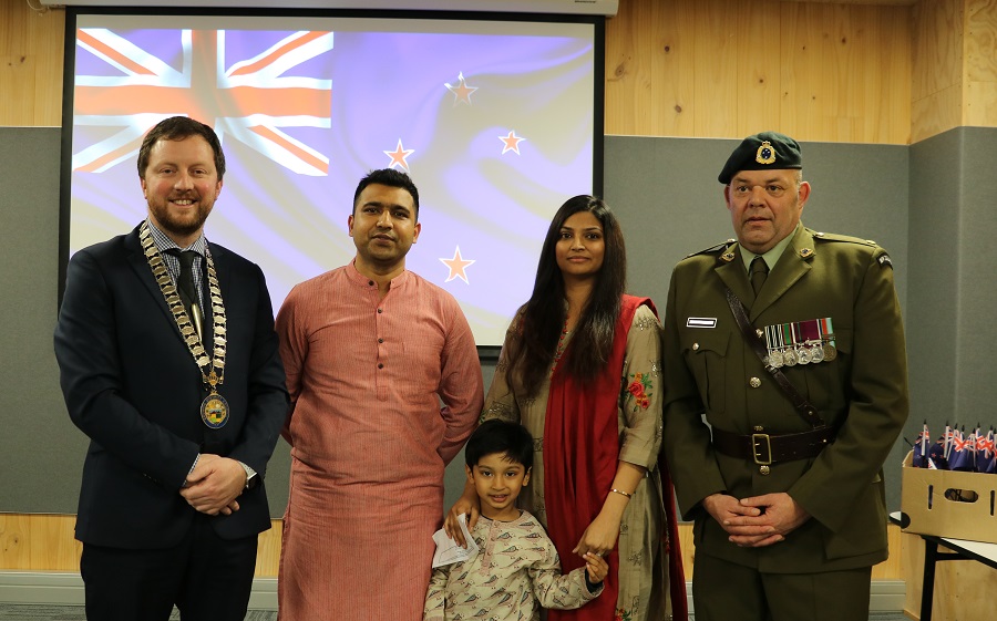 Mayor Sam Broughton and Major Grant Payton stand either side of an Indian man, woman and child in traditional dress