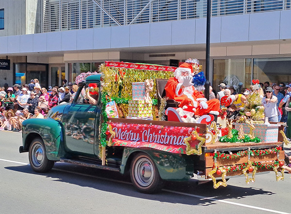 Santa on a float and children waving in background