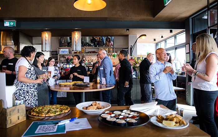 Several people gather to network at restaurant