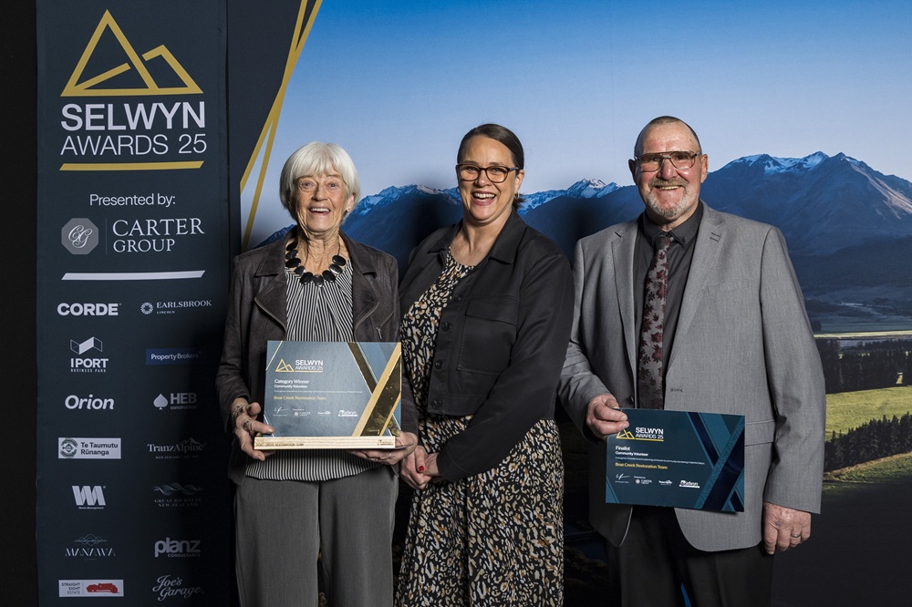 Three smiling members of the Boat Creek Restoration team with their awards for Community Volunteer