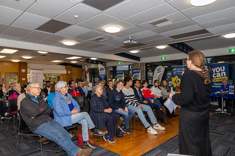 Person presenting at talk in front of crowd