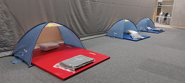 three tents set up inside with mattresses