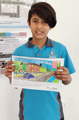 Child holding up winning colouring competition entry