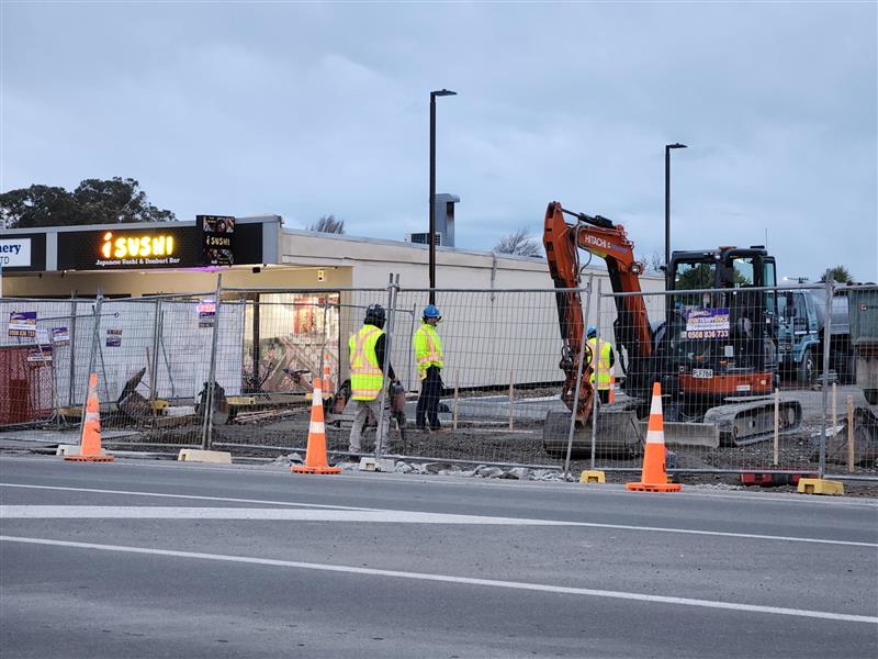 Workers on site beside road